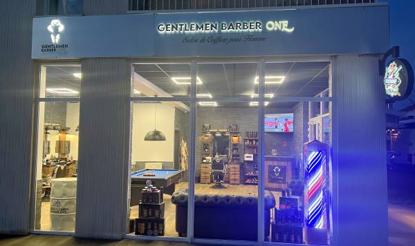 Devanture illuminée du salon Gentlemen Barber One de nuit
